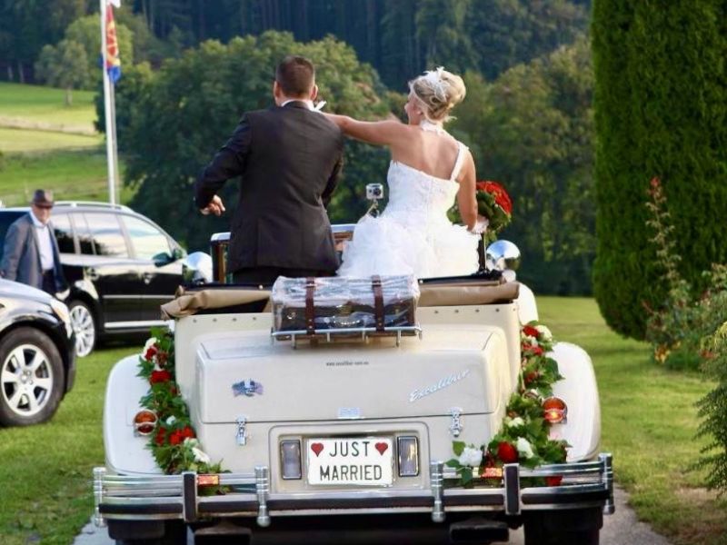 Voiture Excalibur lors d'un mariage avec un conducteur et les mariés.